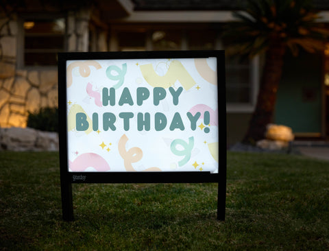 Colorful illuminated birthday yard sign used as creative lawn decor
