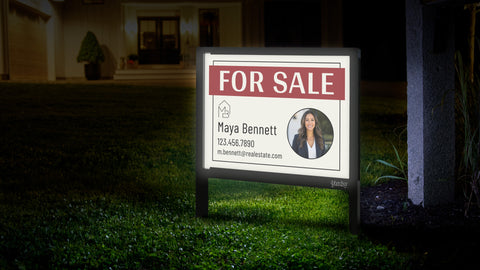 Illuminated Yardsy real estate sign glowing at night in front of a home
